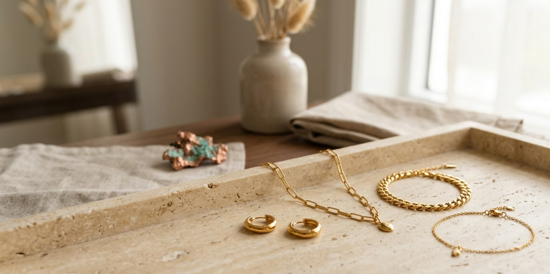 Gold-tone jewelry displayed beside copper with a subtle green patina