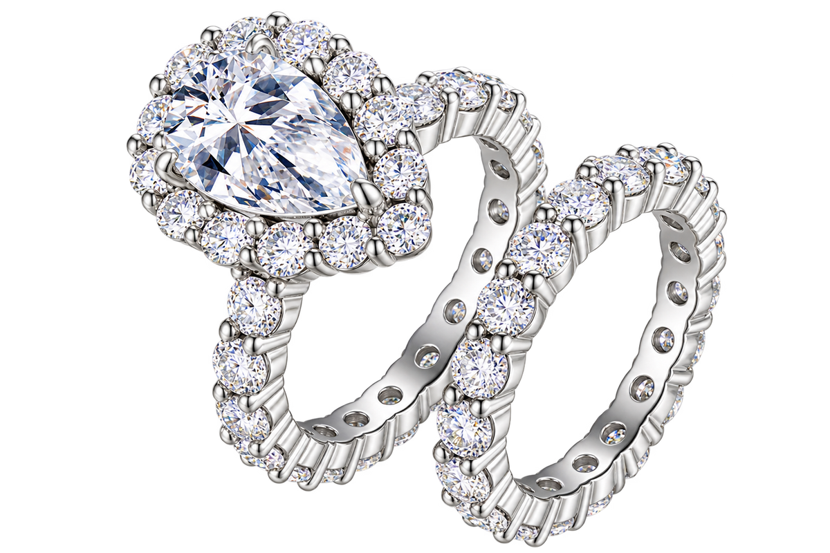 The Pear Halo Set: 7 × 11 mm pear moissanite in a halo with a matching pavé eternity band — sterling silver two-ring set