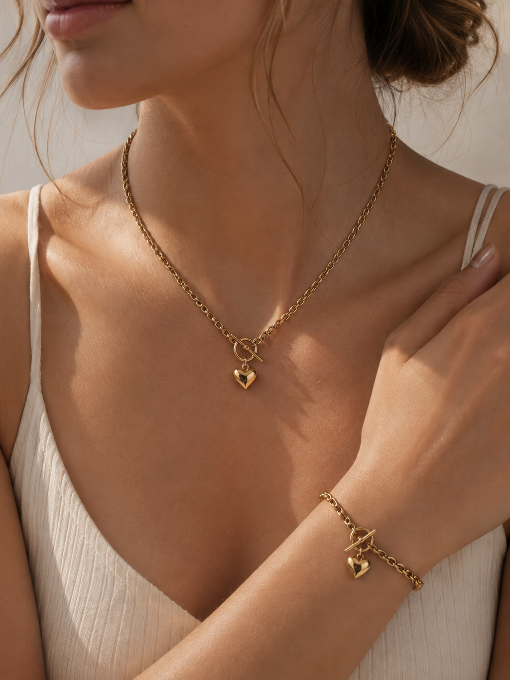 Gold-tone heart necklace and matching bracelet worn together