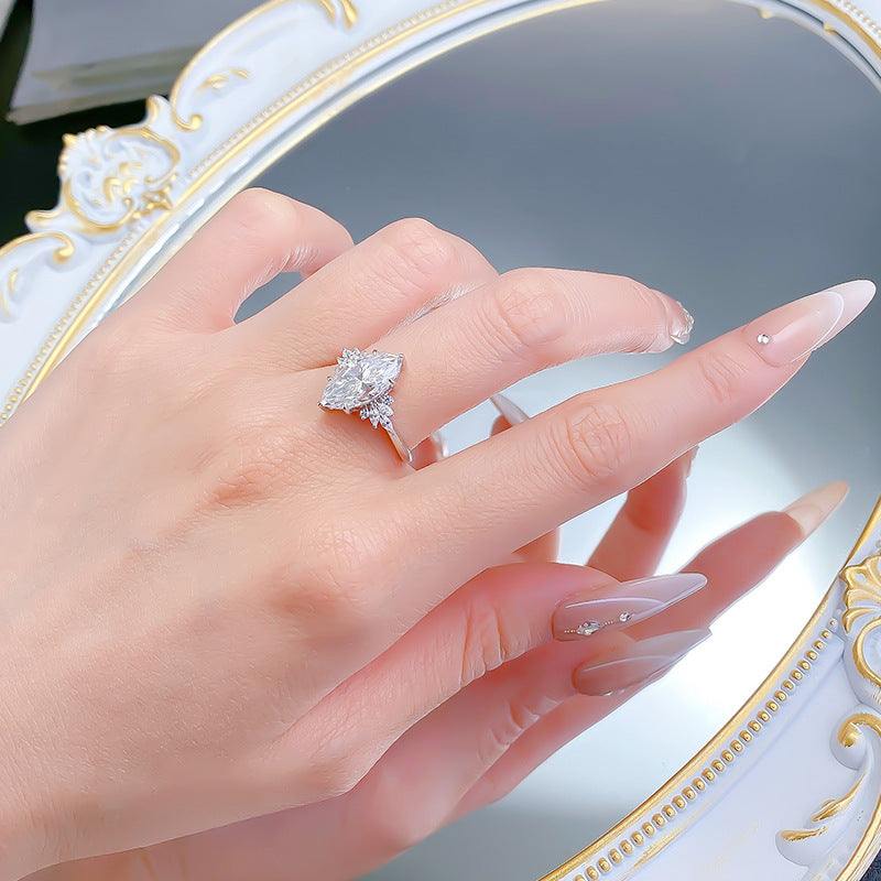 Sterling silver marquise moissanite ring on a hand, angled to catch the light