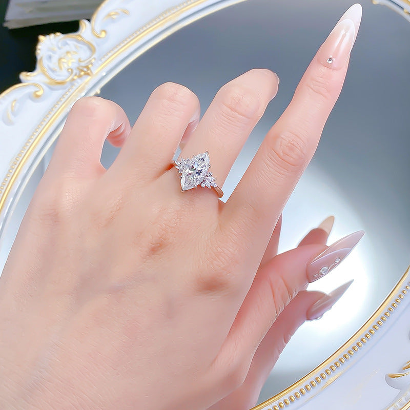 Marquise moissanite ring worn on the ring finger, hand held over a mirror