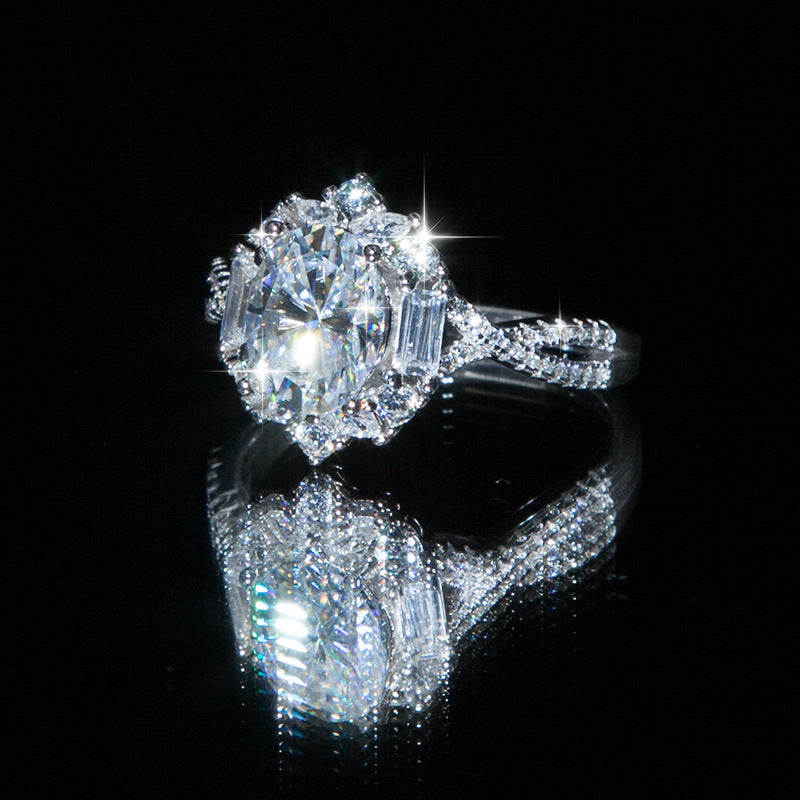 Oval moissanite sterling silver halo ring with split pavé band, angled view