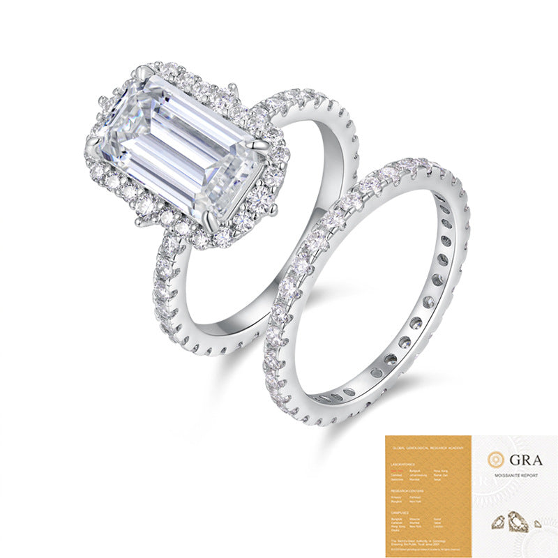The Emerald Halo Set: 7 × 12 mm emerald-cut moissanite in a halo on a pavé shank, with a matching pavé band — sterling silver two-ring set