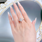Marquise moissanite ring on the ring finger, hand laid flat over a mirror