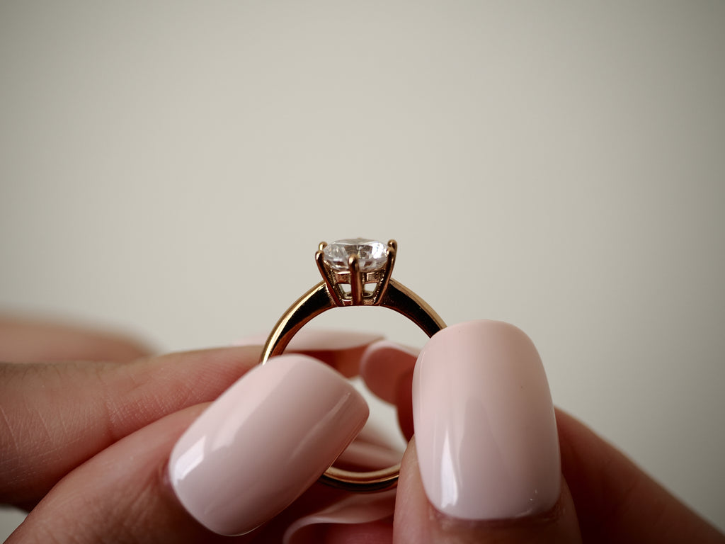 Side view of rose gold-tone six-prong cubic zirconia solitaire ring