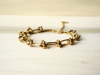 Gold-tone Knot Link bracelet arranged on cream fabric