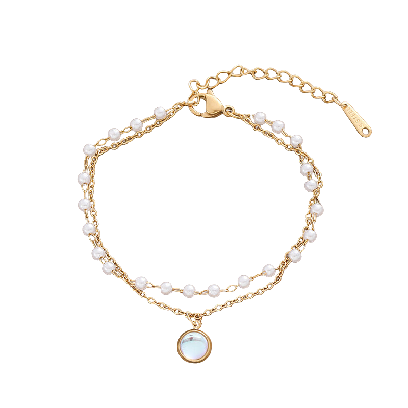 Layered gold-tone bracelet with faux pearls and round iridescent charm